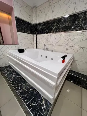 a white sink in a bathroom with black marble at Laleli Suit Hotel in Istanbul
