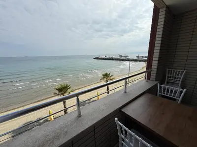 a balcony with a table and a view of the beach at Rumeli Pansiyon in Kumbağ
