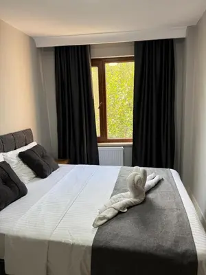 a white towel on a bed with a window at Rumeli Pansiyon in Kumbağ