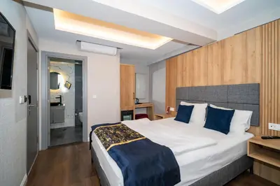 a hotel room with a large bed with blue pillows at Hotel Martini in Istanbul