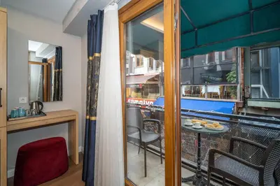 a room with a balcony with a table and chairs at Hotel Martini in Istanbul