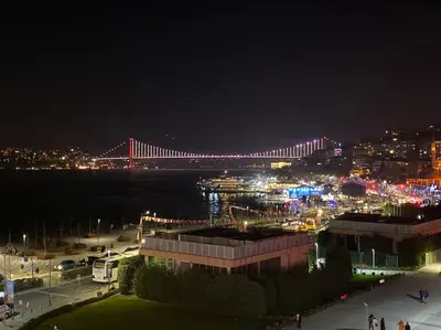 a view of a bridge at night with a city at Boğaz Yalı Dairesi in Istanbul