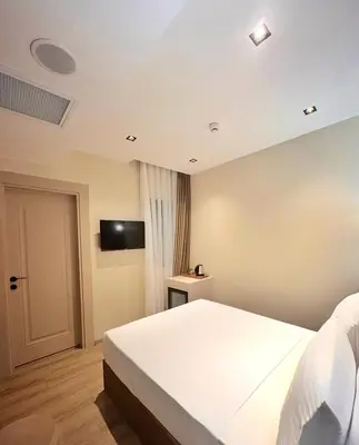a bedroom with a white bed and a television at Park Dedeman Sisli - Istanbul City Center in Istanbul