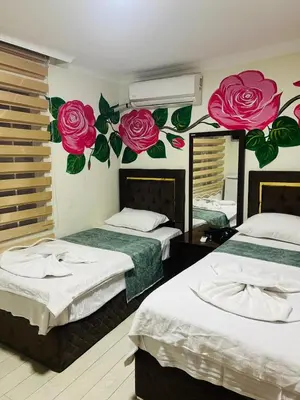 two beds in a room with roses mural on the wall at sefa yacht hotel in Istanbul