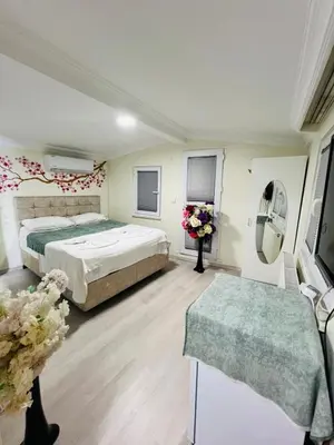 a bedroom with a bed and a table and flowers at sefa yacht hotel in Istanbul
