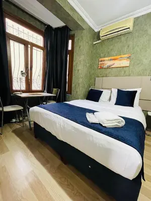 a bedroom with a large bed with blue and white sheets at Taksim Historic House hotel in Istanbul
