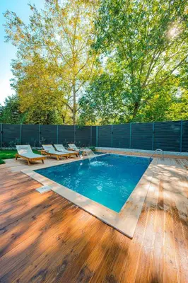 a pool on a wooden deck with chairs and a fence at Nevbahar Sapanca ile Lüks Bir Tatile Merhaba Deyin in Sapanca