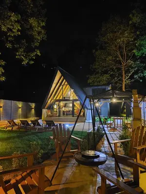 a large wooden house with a group of chairs at night at Nevbahar Sapanca ile Lüks Bir Tatile Merhaba Deyin in Sapanca