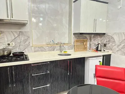 a kitchen with a sink and a red chair at Ayasofya suıtes apart otel in Istanbul