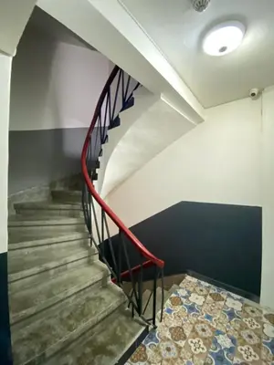 a staircase with a red railing and a tile floor at Asmaaltı GUEST HOUSE in Bursa