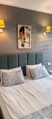 a bed with two pillows and a picture on the wall at Asmaaltı GUEST HOUSE in Bursa