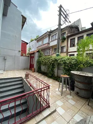 a patio with stairs and a table and a building at Asmaaltı GUEST HOUSE in Bursa