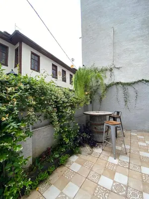 a chair sitting on a patio next to a building at Asmaaltı GUEST HOUSE in Bursa