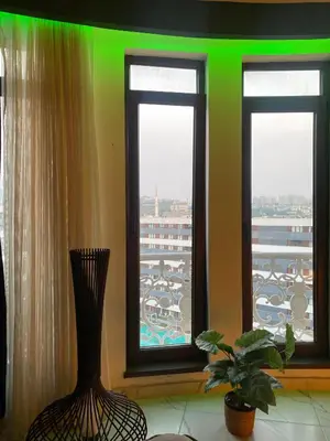 a room with three windows with a vase and a plant at paradise hotel in Istanbul