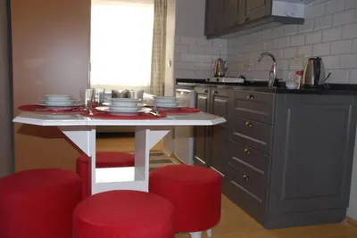 a kitchen with a white table and red stools at Ozcans Pera Flats 4 in Istanbul