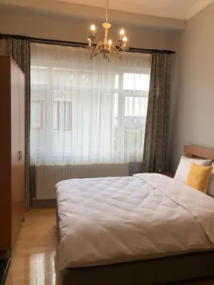 a bedroom with a bed with a chandelier and a window at Ozcans Pera Flats 5 in Istanbul