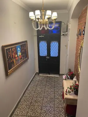 a hallway with a black door and a chandelier at Ozcans Pera Flats 5 in Istanbul
