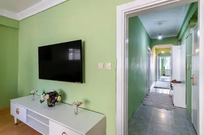 a hallway with green walls and a television on a wall at Şehir Manzaralı Ferah Daire in Istanbul