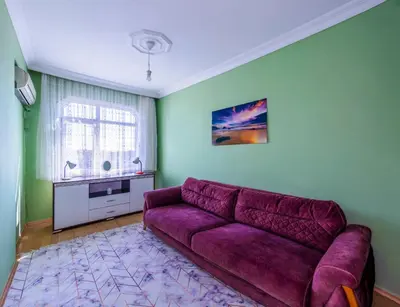 a purple couch in a living room with a window at Şehir Manzaralı Ferah Daire in Istanbul