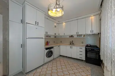 a kitchen with white cabinets and a washer and dryer at Şehir Manzaralı Ferah Daire in Istanbul