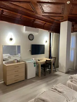 a hotel room with a desk and a bedroom at Adil Konak Hotel in Istanbul