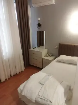 a small bedroom with two beds and a mirror at Adil Konak Hotel in Istanbul