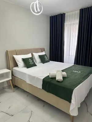 a bedroom with a large bed with green and white pillows at Royal Suit in Bandırma