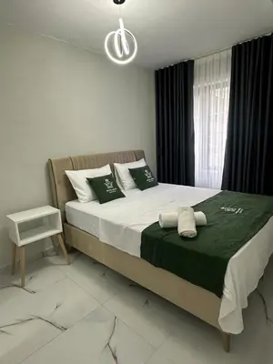 a bedroom with a large bed with green and white pillows at Royal Suit in Bandırma