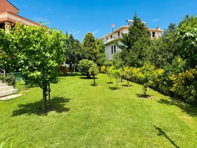 a garden with trees and a house in the background at Treekos Boutique Hotel Istanbul Airport in Karaburun