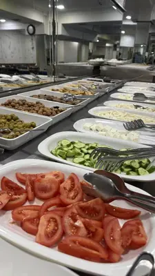 a row of plates of food with tomatoes and cucumbers at Kurban Otel in Istanbul