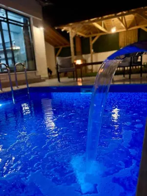 a water fountain in a swimming pool at night at Quiet House in İznik