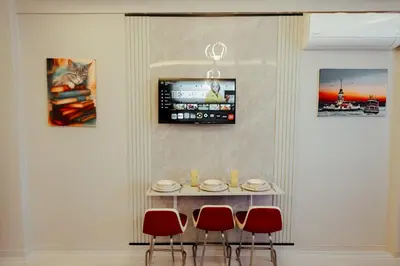 a table with four chairs and a tv on a wall at The Old Bazaar Suites Apartment in Istanbul
