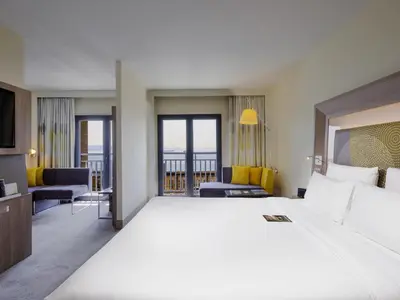 a hotel room with a large bed and a balcony at Novotel Istanbul Bosphorus Hotel in Istanbul