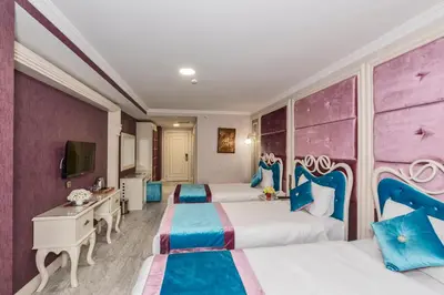 a hotel room with three beds with blue and purple at Marnas Hotels in Istanbul