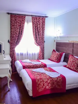 two beds in a hotel room with a window at Hotel SPHENDON in Istanbul