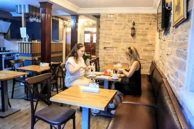 two women sitting at tables in a restaurant at Hotel SPHENDON in Istanbul