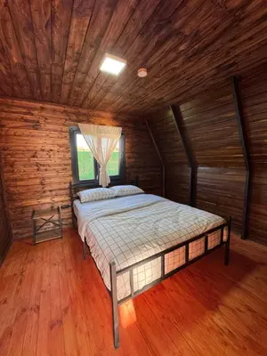a bedroom with a bed in a wooden room at Shadeoffgreenbungalow
