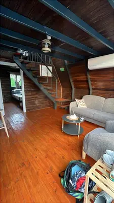a living room with a couch and a table at Shadeoffgreenbungalow
