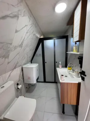 a white bathroom with a toilet and a sink at Shadeoffgreenbungalow
