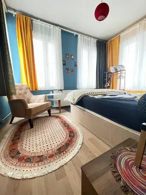 a bedroom with a bed and a chair and a rug at Taksim Square home in Istanbul