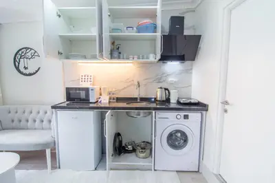 a kitchen with a sink and a washing machine at Cozy 1BR with Inviting Balcony in Beylikduzu