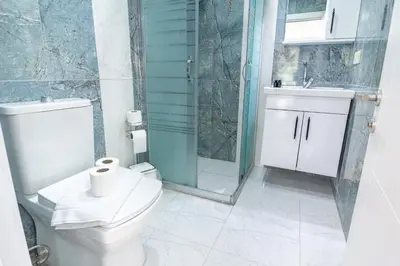 a bathroom with a toilet and a glass shower at Cozy 1BR with Inviting Balcony in Beylikduzu
