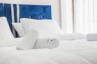 a white bed with a towel on top of it at Cozy 1BR with Inviting Balcony in Beylikduzu