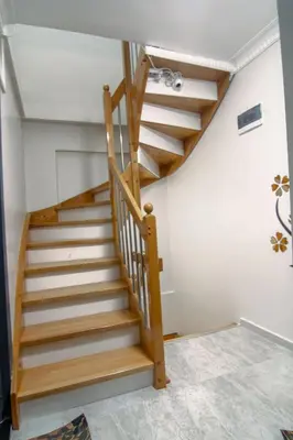 a wooden staircase in a room with white walls at Cozy 1BR & Sofabed with Two Inviting Balconies in Beylikduzu
