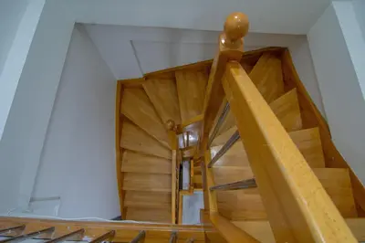 a wooden spiral staircase in a house with wooden floors at Cozy 1BR & Sofabed with Two Inviting Balconies in Beylikduzu