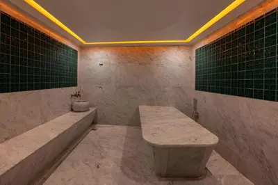 a bathroom with a bench and a sink and green tiles at QUİ Hotel&SPA in Istanbul
