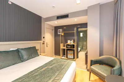 a hotel room with a bed and a chair at QUİ Hotel&SPA in Istanbul