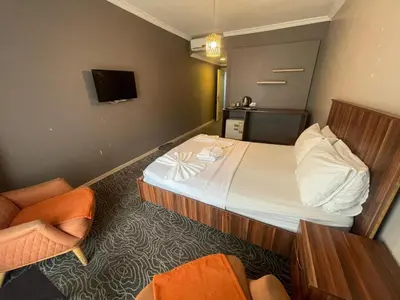 a hotel room with a bed and a chair at Ser Suite Apart Hotel in Esenyurt