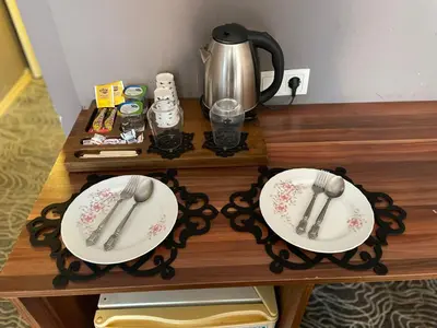a wooden table with two plates and a tea kettle at Ser Suite Apart Hotel in Esenyurt