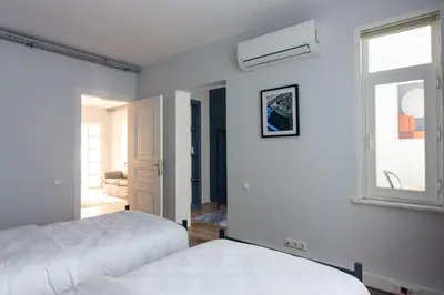 a white bedroom with two beds and a window at Modern Duplex with Large Terrace in Cihangir in Istanbul